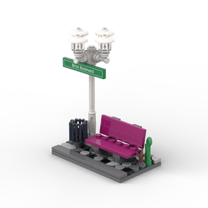 Weißer Laternenpfahl mit Bank - Grünes Schild